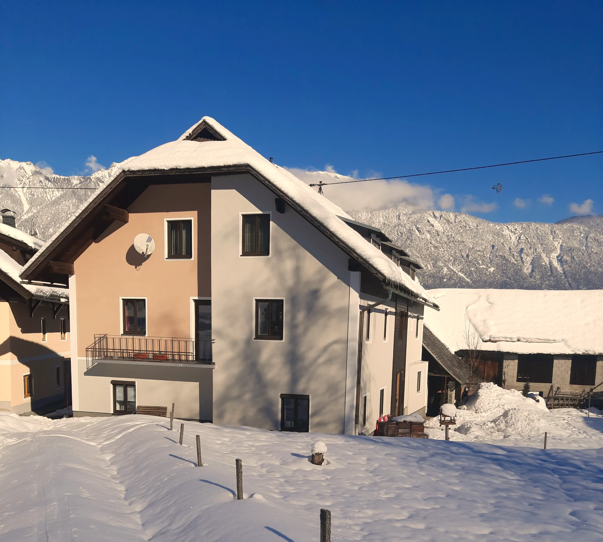Haus Nampolach tief verschneit unter blauem Himmel